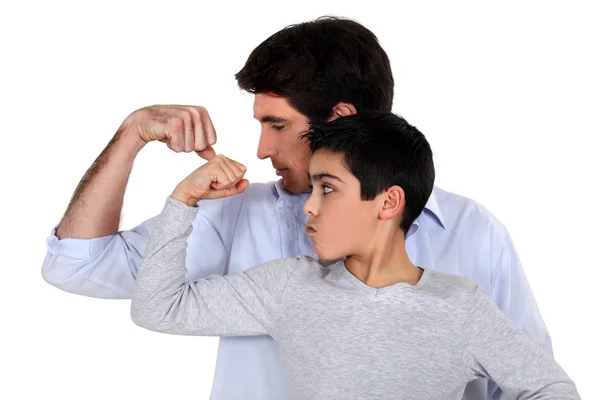 Pai e filho comparando seus músculos — Fotografia de Stock