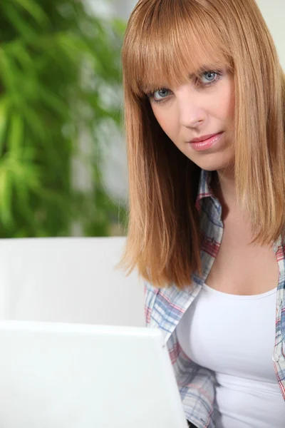 Twentysomething kvinna sitter på en bärbar dator — Stockfoto
