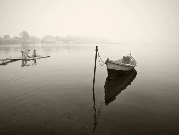 Oude houten boot in mist, zwart-wit — Stockfoto