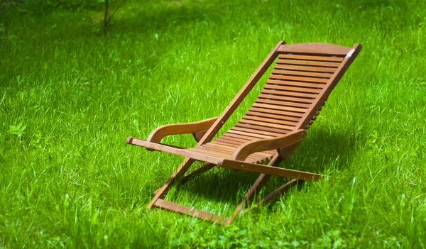 Chaise longue in het gras Stockafbeelding