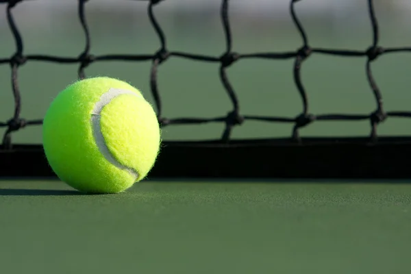 Теннисный мяч рядом с сетью — стоковое фото