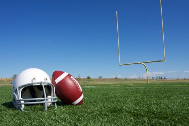 Football and Helmet on the Field clipart