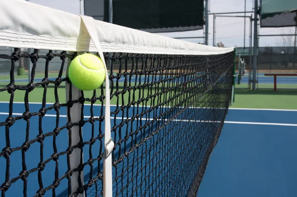 Теннисный мяч в сетке — стоковое фото