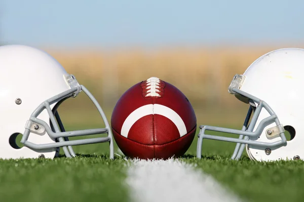フィールド上のヘルメットとアメリカン フットボール — ストック写真