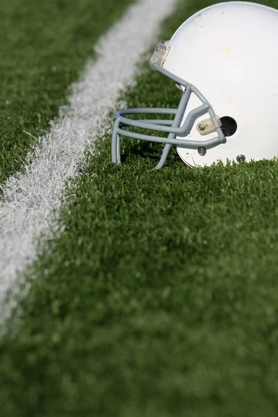 Американский футбольный шлем на поле — стоковое фото