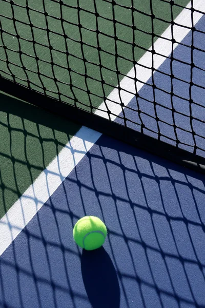 Tenisový míček v stínu sítě — Stock fotografie