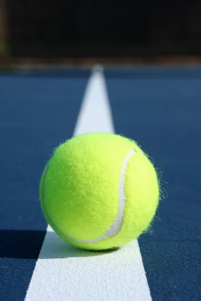 Balle de tennis sur un terrain bleu — Photo