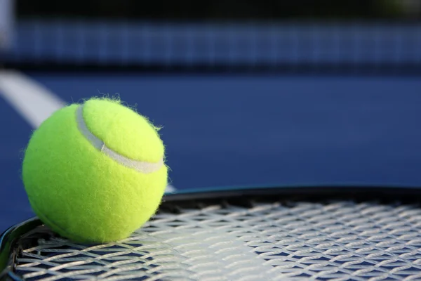 Теннисный мяч на ракетке — стоковое фото