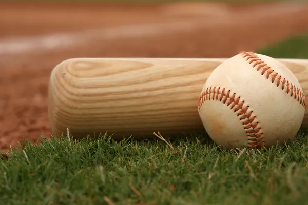 Béisbol y murciélago en el campo — Foto de Stock
