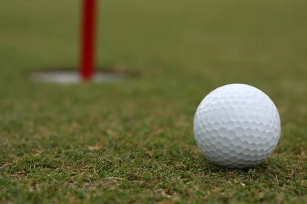 Golfball in der Nähe des Pokals — Stockfoto