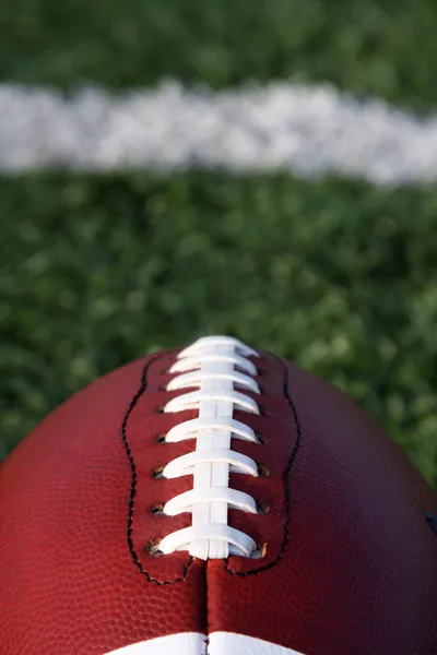Football close up with yard line beyond — Stock Photo, Image