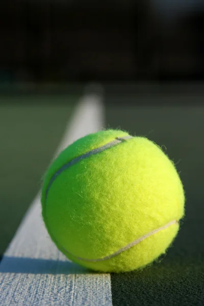 Balle de tennis avec ligne de court fanée — Photo