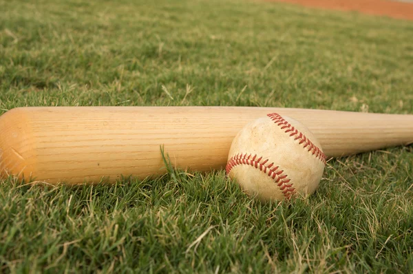 Бейсбол и летучая мышь на грассе — стоковое фото
