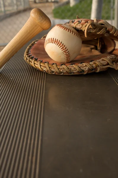 Бейсбол и летучая мышь на скамейке — стоковое фото