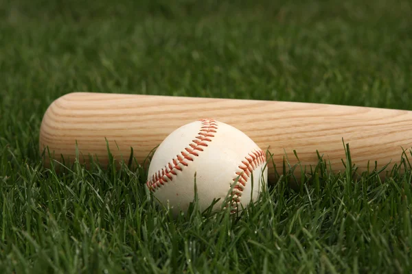 Beisebol e morcego na grama — Fotografia de Stock