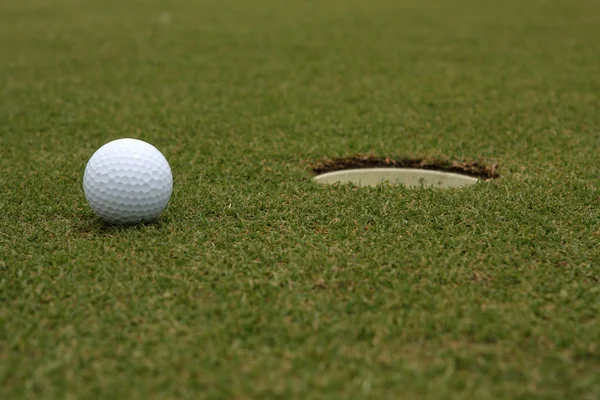 Golfball in der Nähe des Pokals — Stockfoto