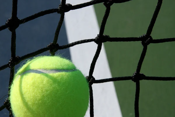 Tennisboll mot nätet — Stockfoto