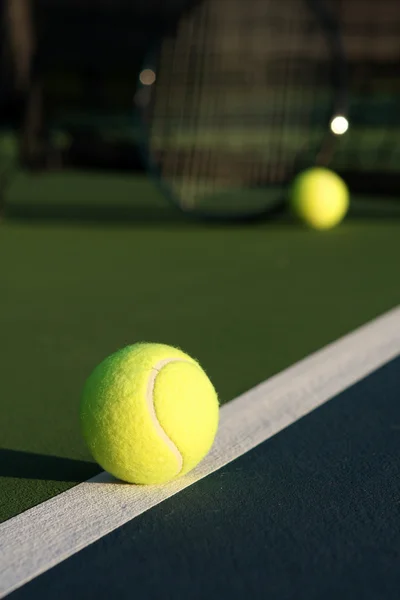 Bola de tênis com raquete no fundo — Fotografia de Stock