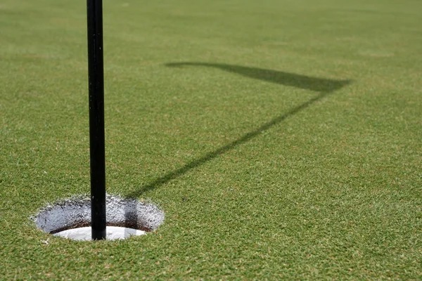 ゴルフの穴とフラグの影 — ストック写真