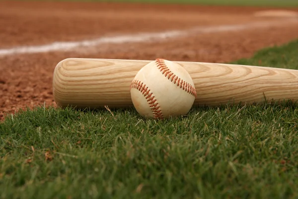 Бейсбол и летучая мышь на грассе — стоковое фото