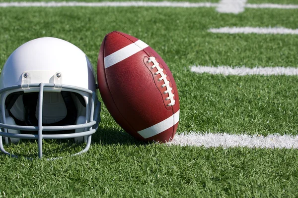 Voetbal en helm op het veld — Stockfoto