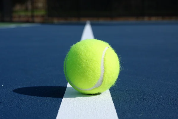 Bola de tênis em uma quadra moderna azul — Fotografia de Stock