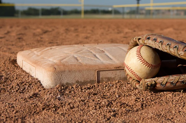 Бейсбол и перчатка возле второй базы — стоковое фото