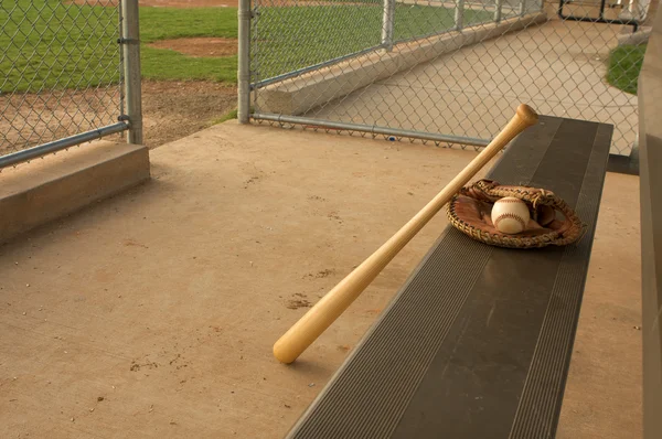 Baseballová pálka a rukavice na lavičce — Stock fotografie