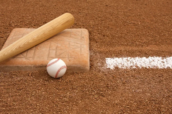Beisebol e morcego perto da base — Fotografia de Stock