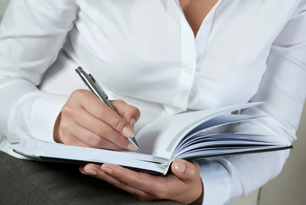 Businesswoman writing on notepad — Stock Photo, Image