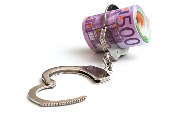 Деньги и наручники — стоковое фото