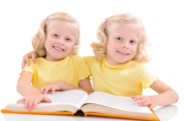 Smiling twins girls with book — Stock Photo, Image