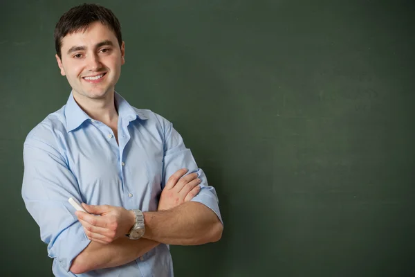 Smiling student or teacher at the blackboard — Stock Photo, Image