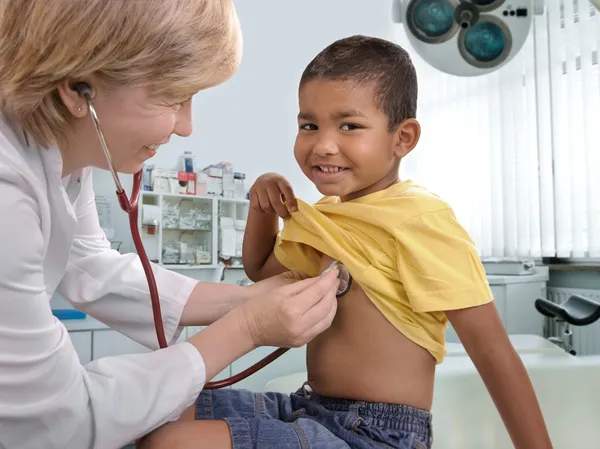 Женщина-врач осматривает маленького мальчика — стоковое фото