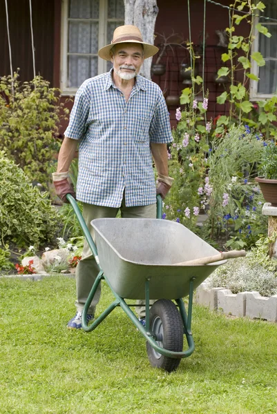 Senior mit Schubkarre im Garten — Stockfoto