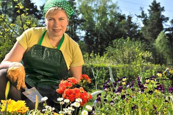 Mujer feliz con flores en su jardín —  Fotos de Stock