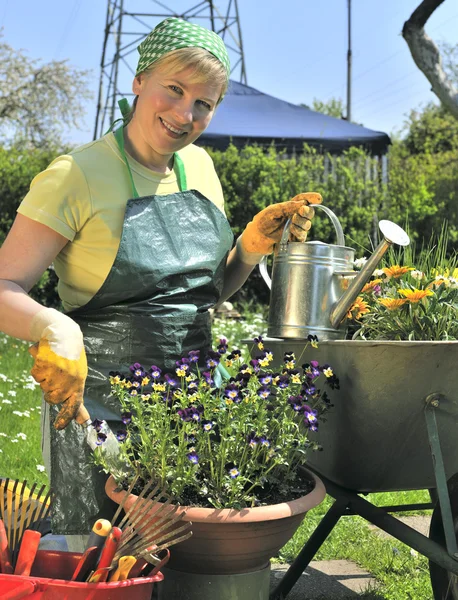 Mujer feliz con flores en su jardín — Foto de Stock