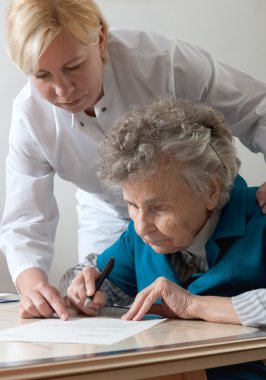 Assisting a senior woman by nurse at home. clipart