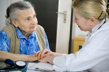 yaşlı bir kadın bir doktor tarafından muayene ediliyor