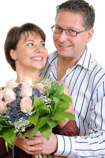 Lyckliga paret med en massa blommor — Stockfoto