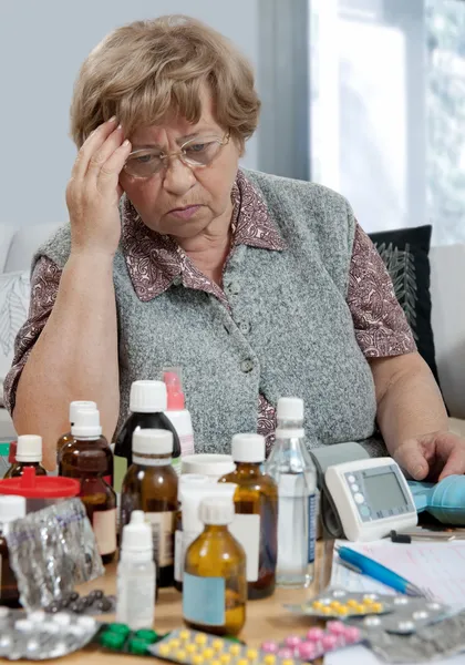 Старша жінка з пляшками ліків — стокове фото