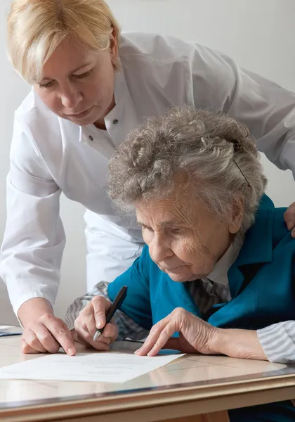 Unterstützung einer Seniorin durch eine Krankenschwester zu Hause. — Stockfoto