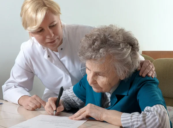 Assisting a senior woman by nurse at home. — Stock Photo, Image