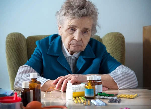 Donna anziana con le sue bottiglie di medicina — Foto Stock