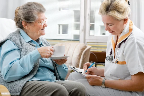 Operatore sanitario e donna anziana — Foto Stock