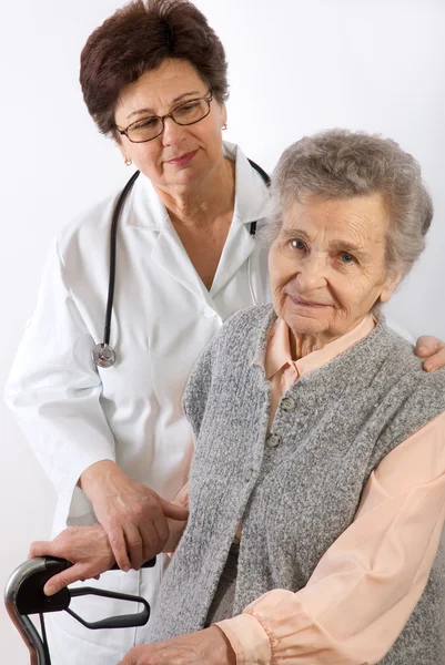 Медицинский работник помогает пожилой женщине — стоковое фото