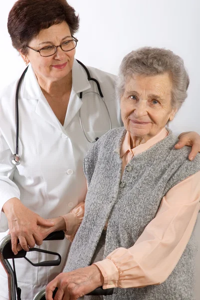 Trabalhador de saúde ajuda a mulher idosa — Fotografia de Stock