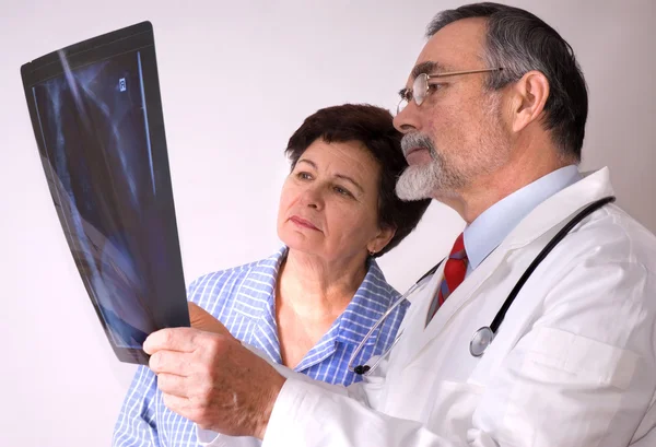 Medico che spiega i risultati dei raggi X al paziente — Foto Stock