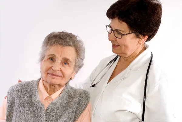 Trabalhador de saúde ajuda a mulher idosa — Fotografia de Stock