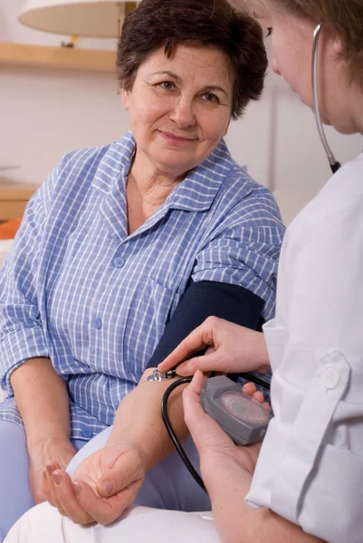 Médico que mede a pressão arterial de um paciente — Fotografia de Stock